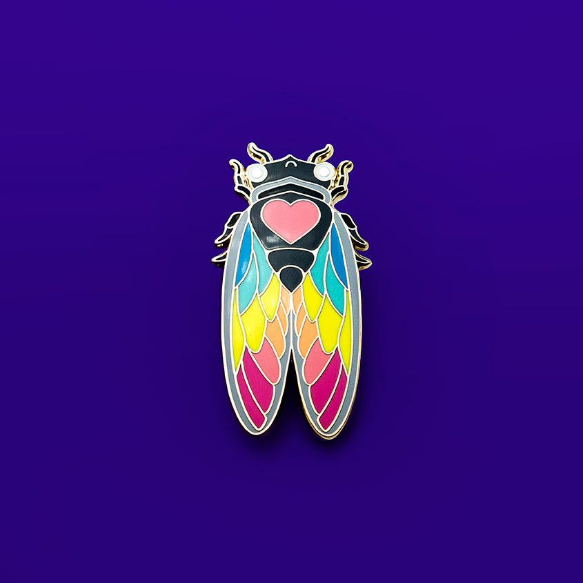 Close-up of the Rainbow Cicada Enamel Pin, showcasing its vibrant colors and intricate details against a white background.