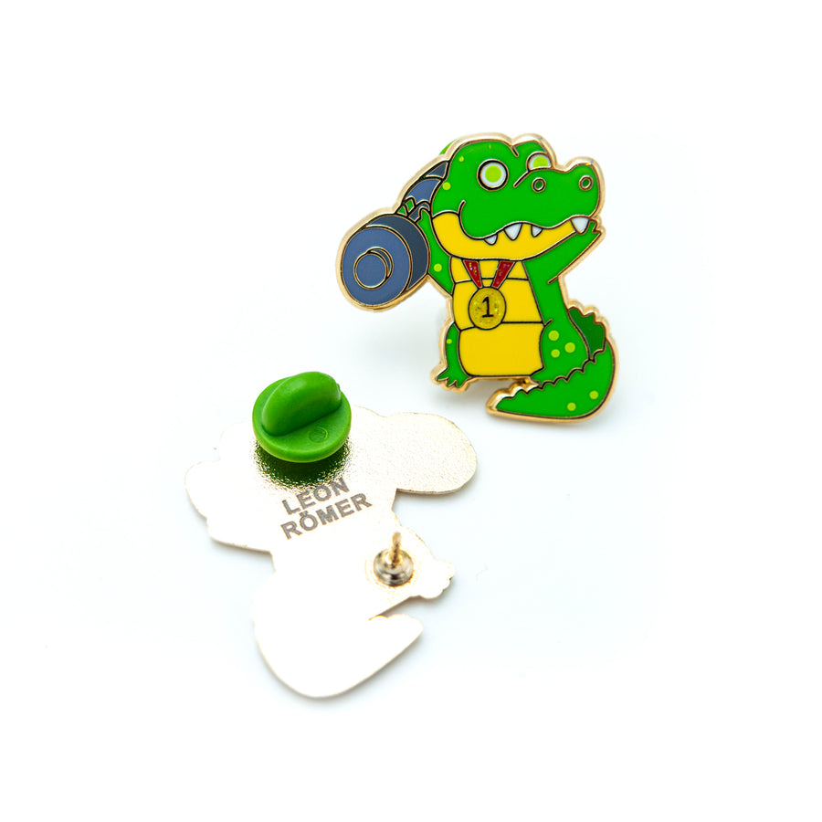 The Crocodile Enamel Pin elegantly displayed on a pin board, a captivating addition to any collection