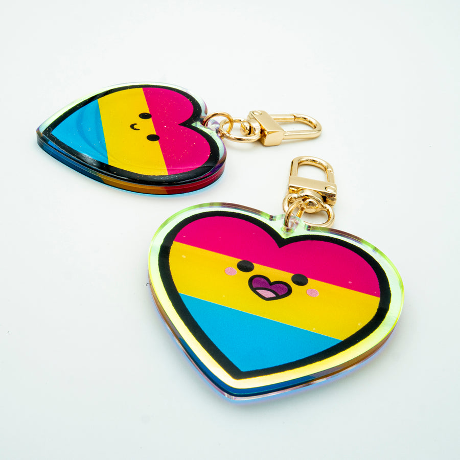 Acrylic rainbow pride keychain with glitter epoxy front and double-sided printing. 2 inches in size with a gold clip hook, celebrating attraction to all genders with a bold, inclusive design.